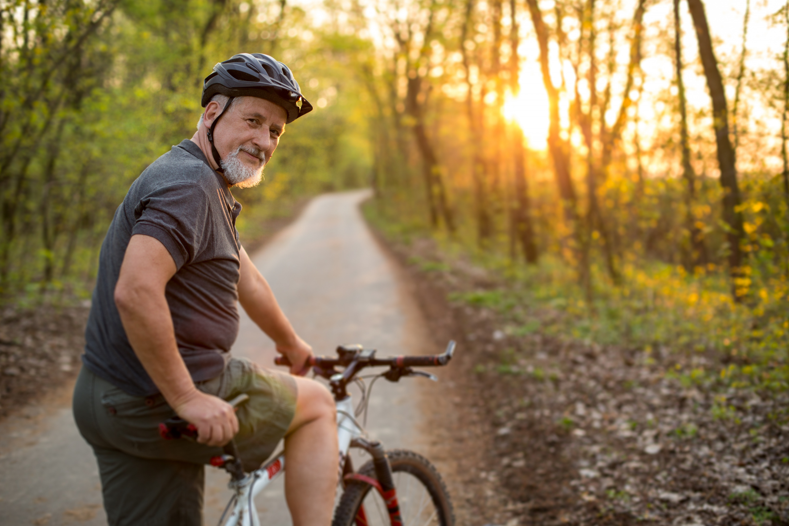 Illustrasjonsfoto. Mann med sykkel i solnedgang.